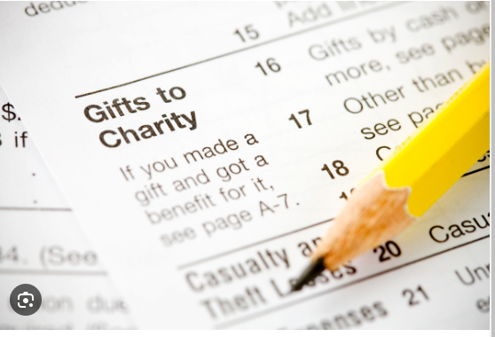 A close-up view of a tax form with a pencil pointing to the "Gifts to Charity" line item, highlighting the opportunity to maximize charitable deductions through strategic gift financing.
